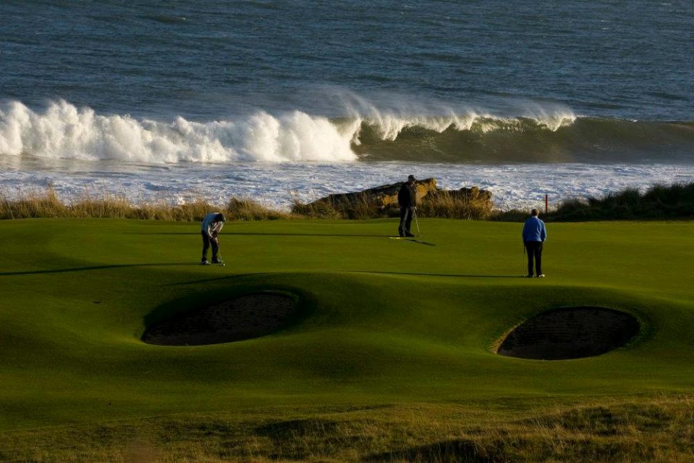 Golfers putting on the 10th hole of the Championship at Royal Dornoch