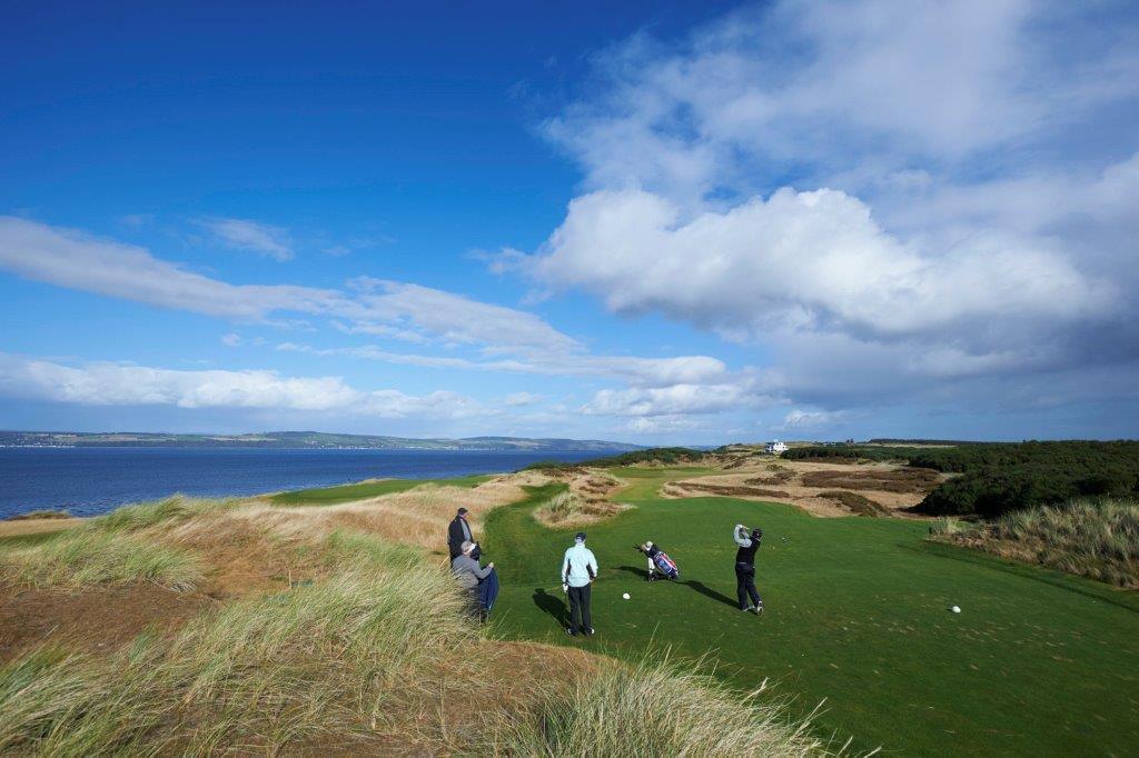 Golfers playing the Par 3 8th at Castle Stuart
