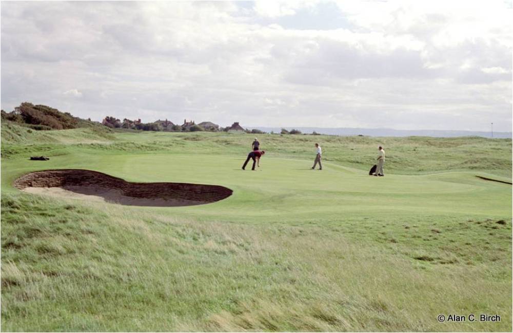 Golfers putting on the Royal Liverpool golf course