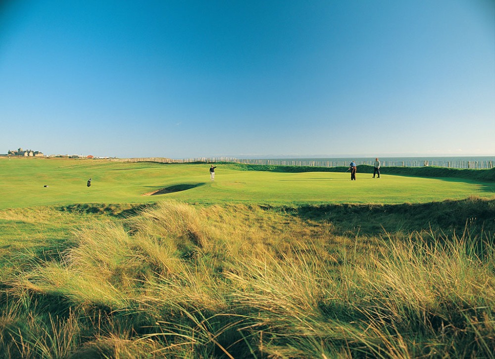 Golfers putting on the Royal Porthcawl golf course