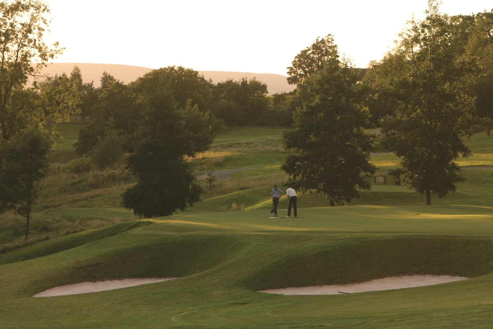 Golfers putting on the Montgomerie course at Celtic Manor