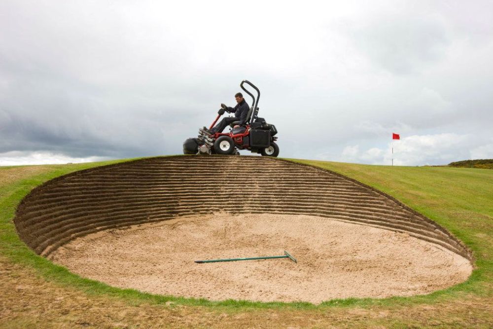 Green keeper and deep bunker on the Championship at Royal Dornoch