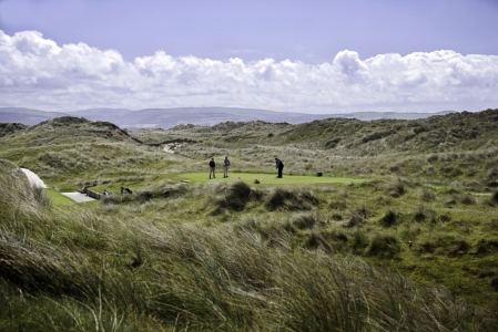 Golfers on a tee surrounded by dunes at Aberdovey