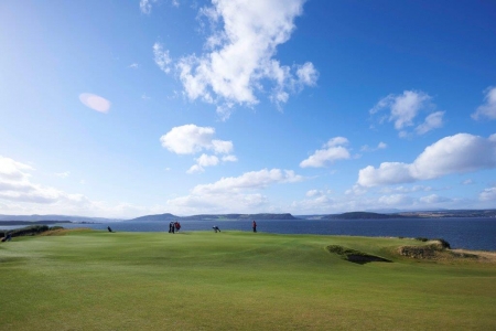 Golfers putting on the 18th green at Castle Stuart