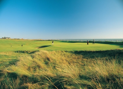 Golfers putting on the Royal Porthcawl golf course