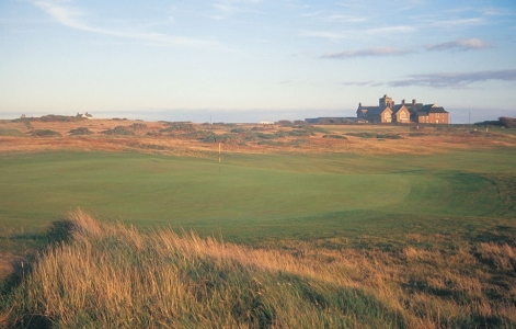 Hole and clubhouse on the Royal Porthcawl golf course