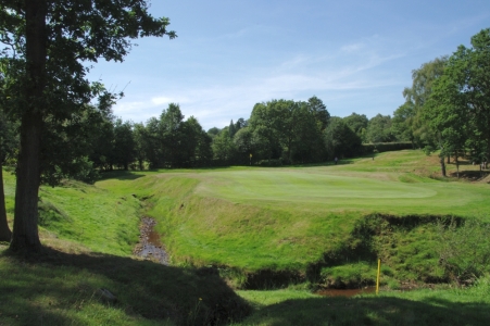 River at the back of a green on the Old Course at the Royal Ashdown Forest golf club
